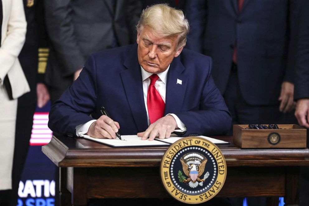 PHOTO: President Donald Trump signs an executive order giving priority to Americans to receive American coronavirus vaccines during the Operation Warp Speed Vaccine Summit at the White House in Washington, DC., Dec. 8, 2020.