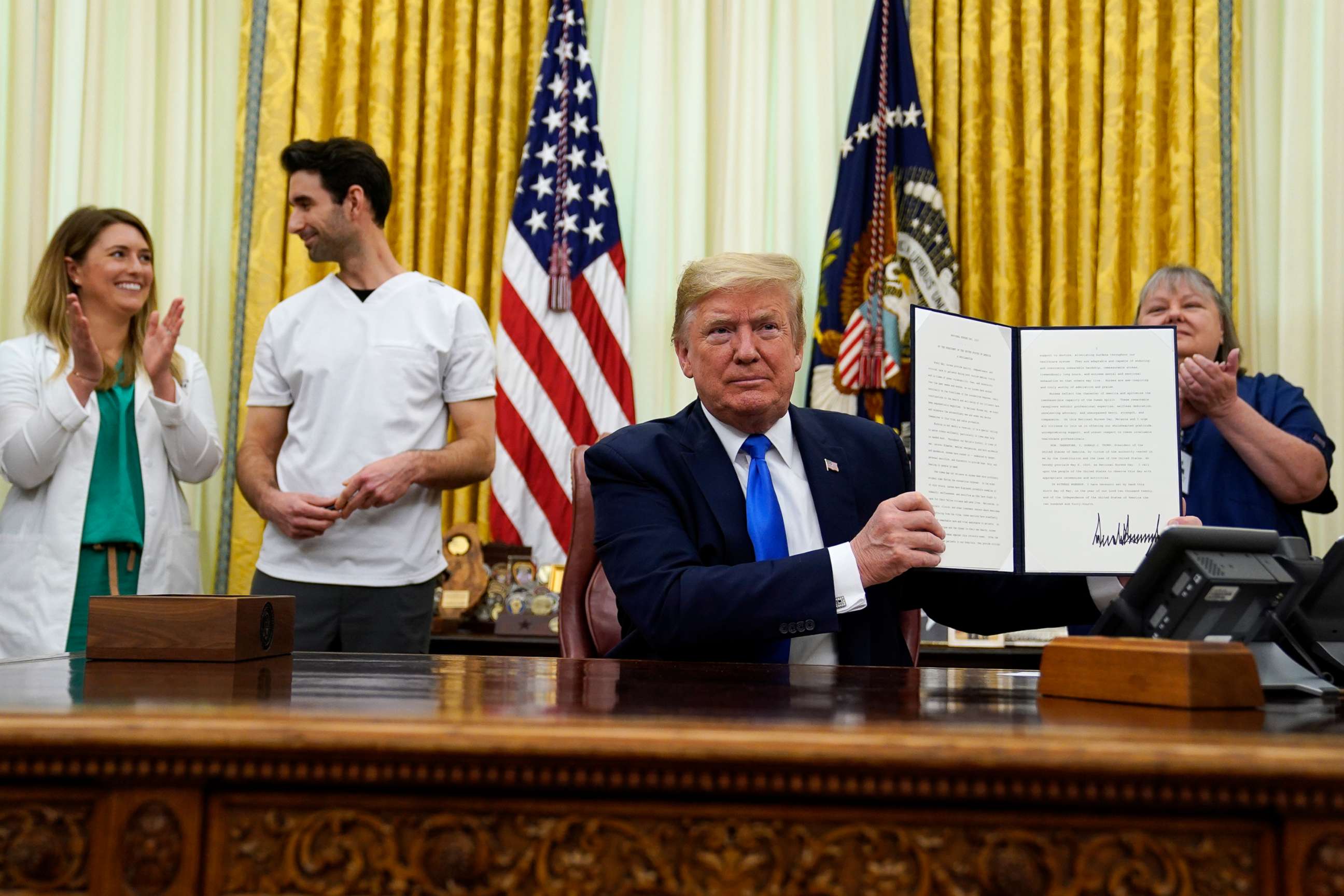 PHOTO: President Donald Trump holds a signed proclamation in honor of World Nurses Day during an event in the Oval Office of the White House, May 6, 2020, in Washington.