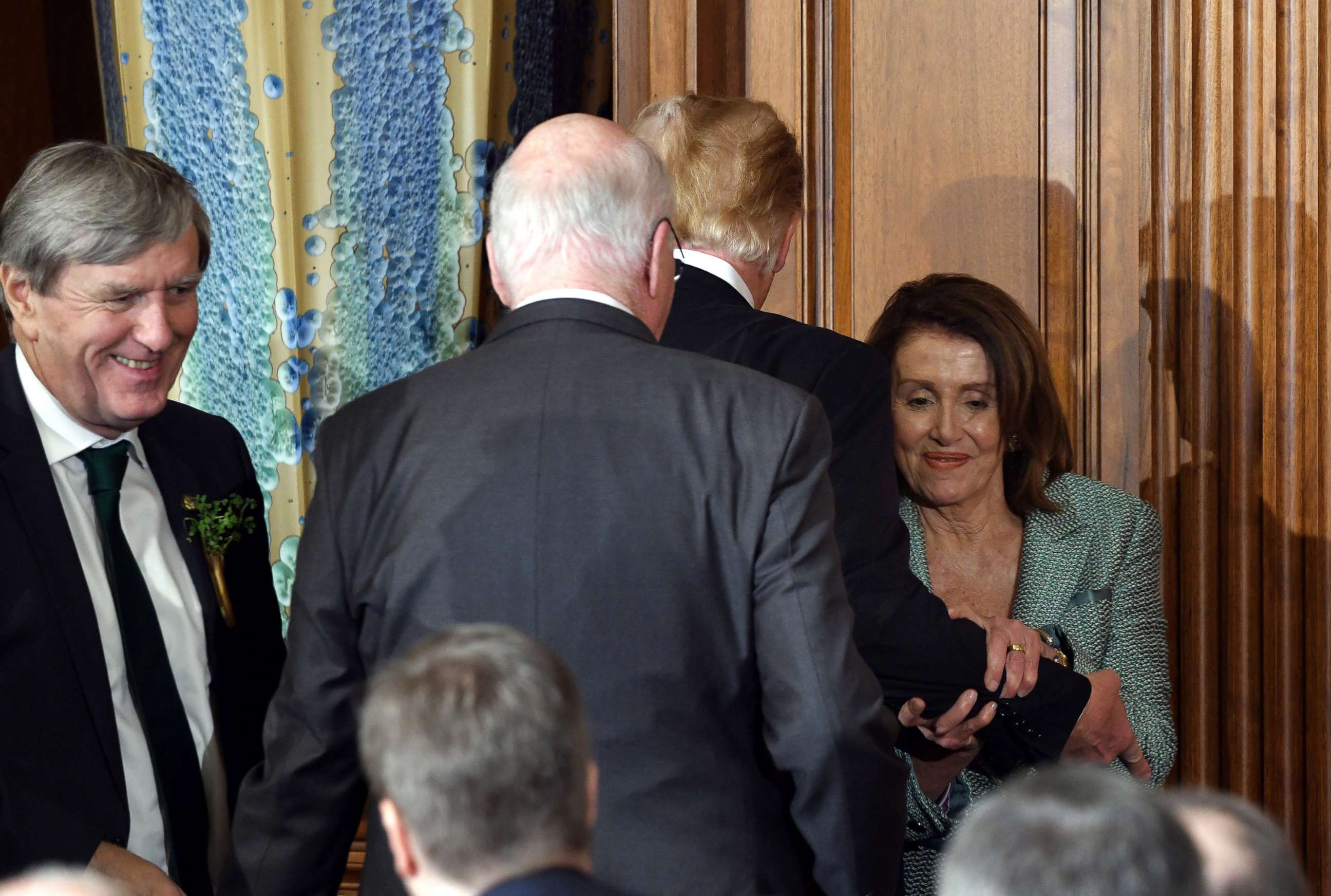 PHOTO: House Speaker Nancy Pelosi grips President Donald Trump's arm as the two pass at the Friends of Ireland Luncheon the Capitol on March 14, 2019, in Washington.