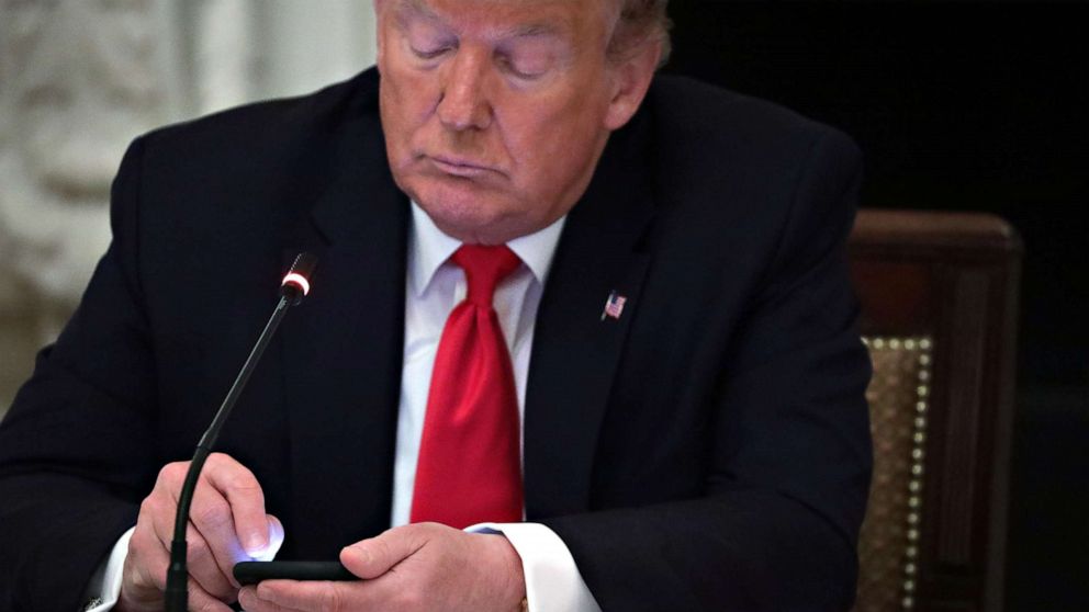 PHOTO: President Donald Trump uses his phone during a roundtable discussion at the State Dining Room of the White House in Washington, June 18, 2020.