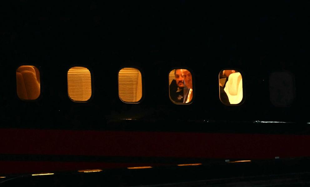 PHOTO: Former President Republican presidential candidate Donald Trump looks out from his plane window as he arrives more than 3 hours late to a campaign rally in Traverse City, Michigan, on Oct. 25, 2024.