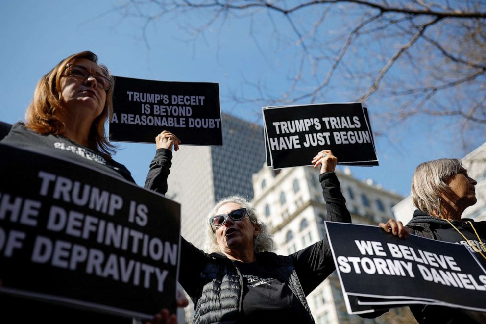 PHOTO: Protesters hold signs outside Manhattan Criminal Courthouse on the day of former President Donald Trump's planned court appearance after his indictment by a Manhattan grand jury, in New York City, April 4, 2023.