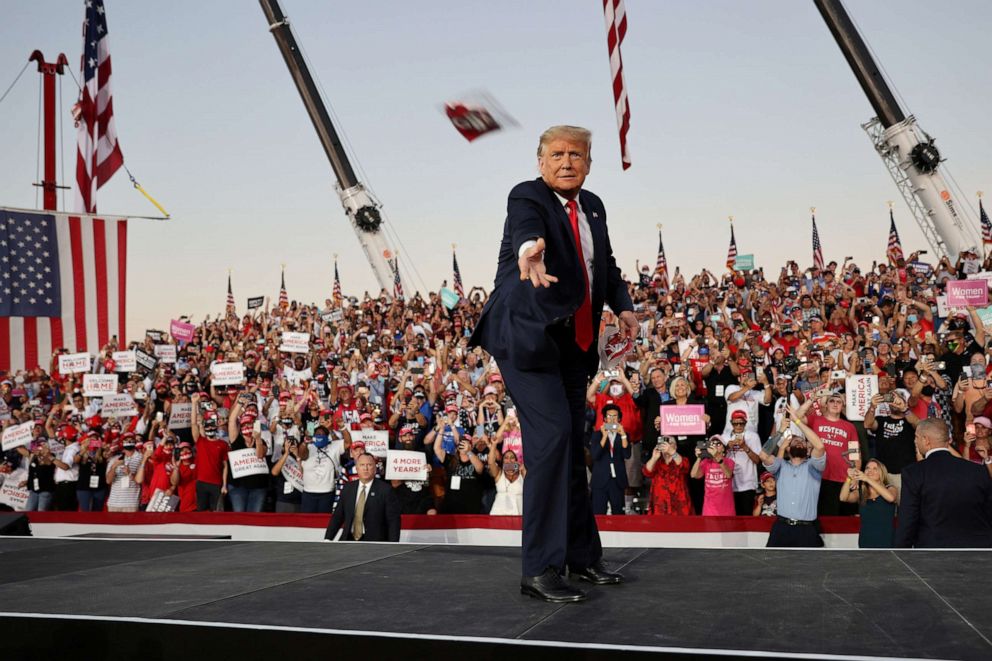 PHOTO: President Donald Trump tosses face masks to the crowd as he takes the stage for a campaign rally, his first since being treated for COVID-19, at Orlando Sanford International Airport in Sanford, Fla., Oct. 12, 2020.