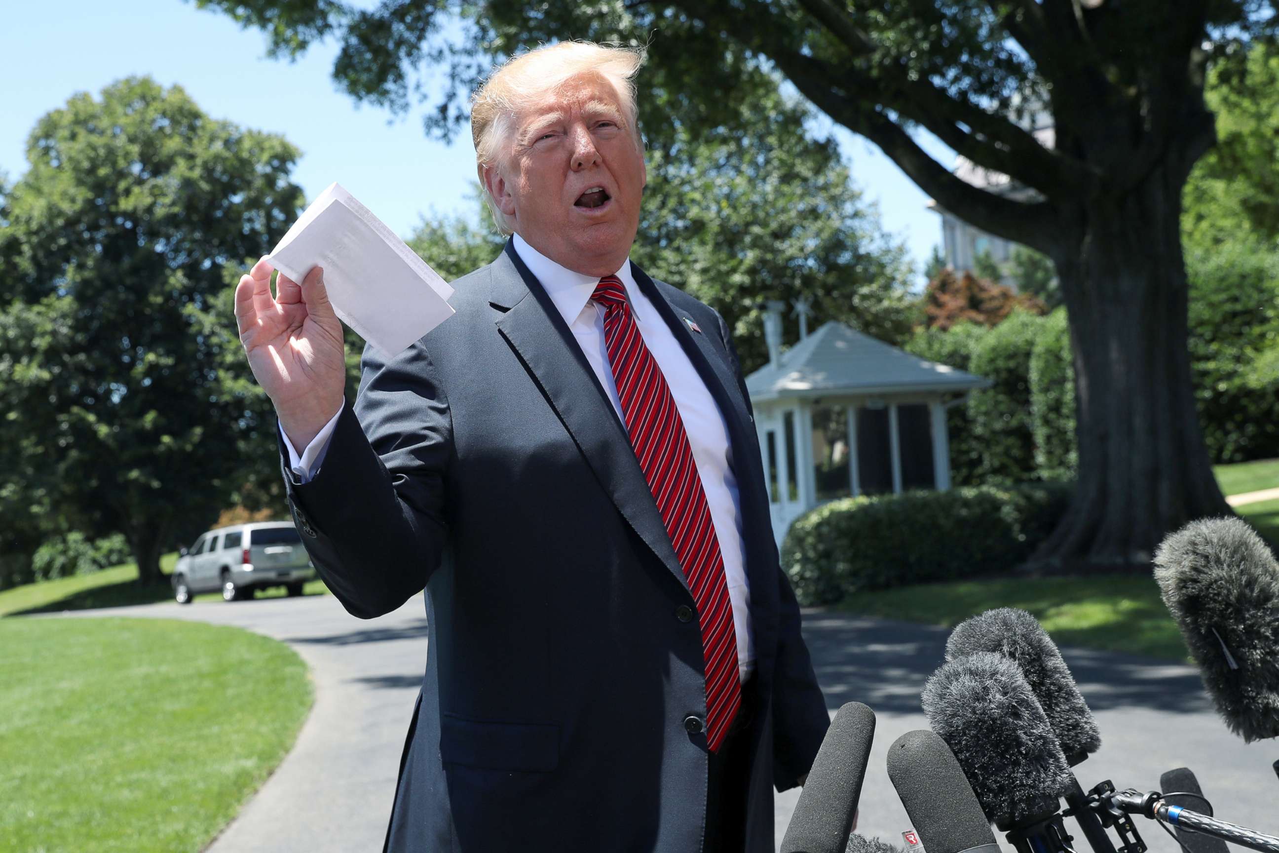 PHOTO: President Donald Trump holds up what he described as proof of a deal with Mexico on immigration and trade as he speaks to the news media prior to departing for travel to Iowa from the South Lawn of the White House, June 11, 2019. 