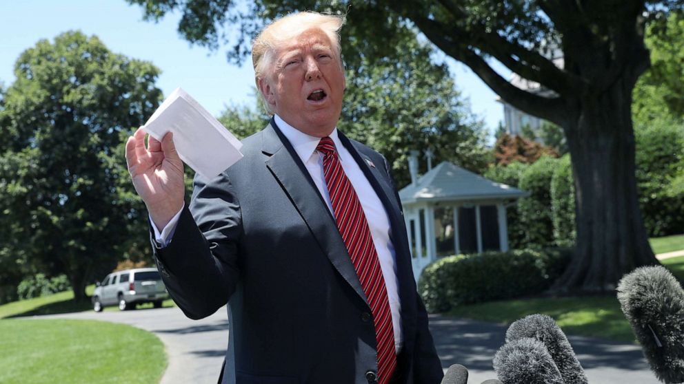 PHOTO: President Donald Trump holds up what he described as proof of a deal with Mexico on immigration and trade as he speaks to the news media prior to departing for travel to Iowa from the South Lawn of the White House, June 11, 2019. 