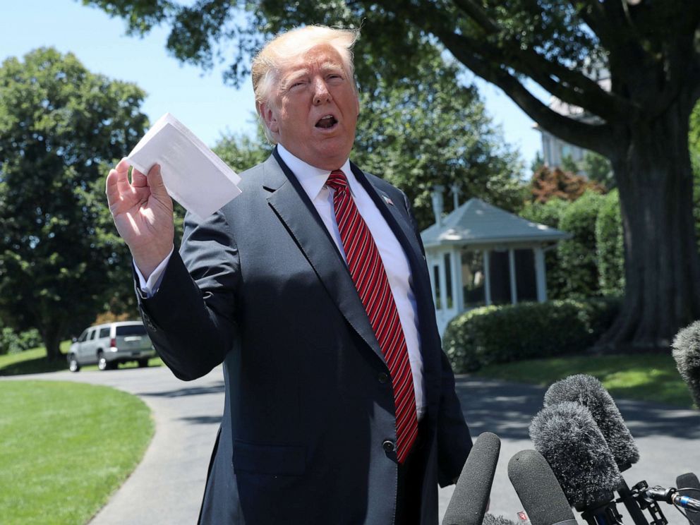 PHOTO: President Donald Trump holds up what he described as proof of a deal with Mexico on immigration and trade as he speaks to the news media prior to departing for travel to Iowa from the South Lawn of the White House, June 11, 2019.
