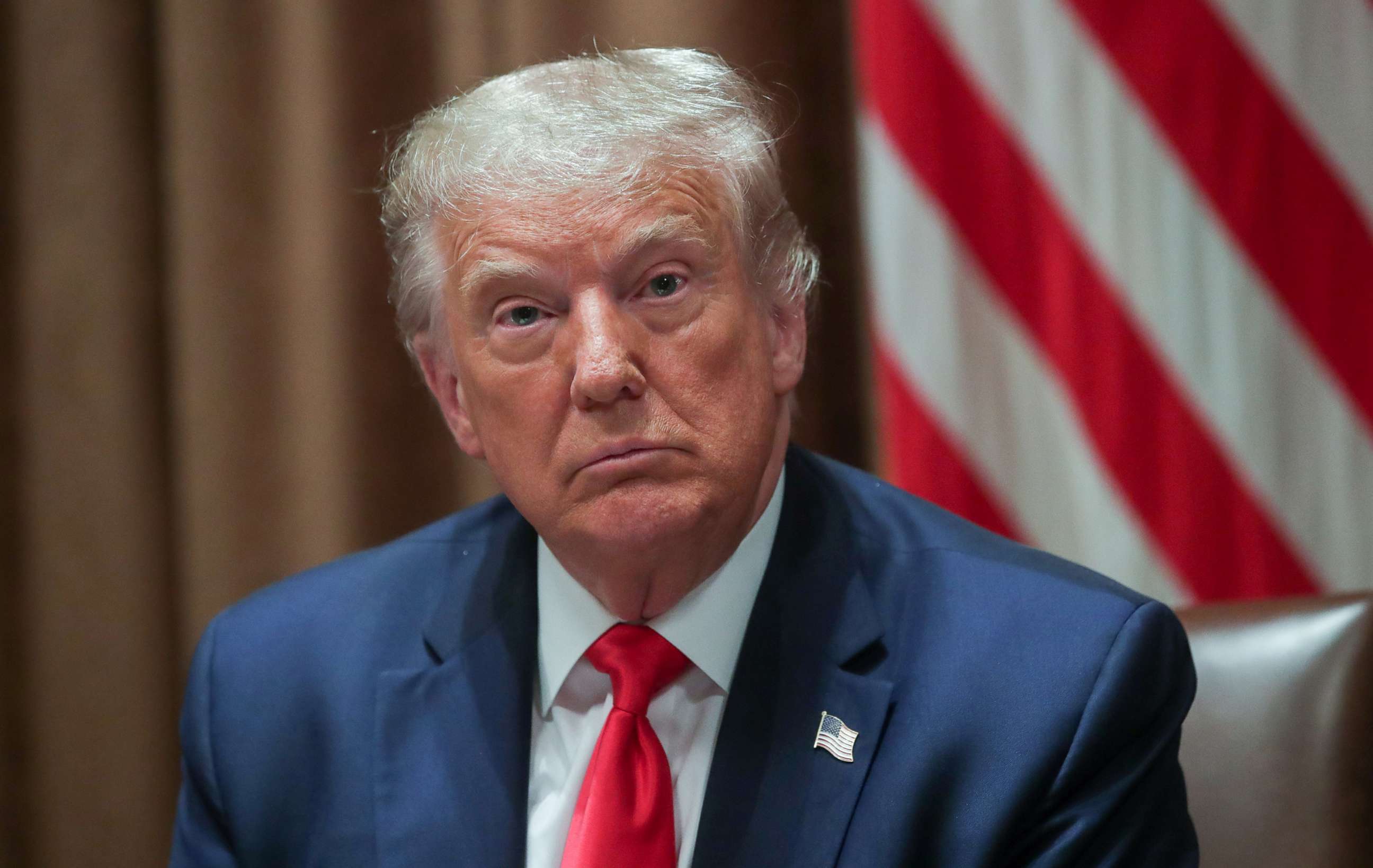 PHOTO: President Donald Trump participates in a signing event for an executive order on "hiring American" in a darkened Cabinet Room of the White House with curtains drawn and the lights low in Washington, Aug. 3, 2020.