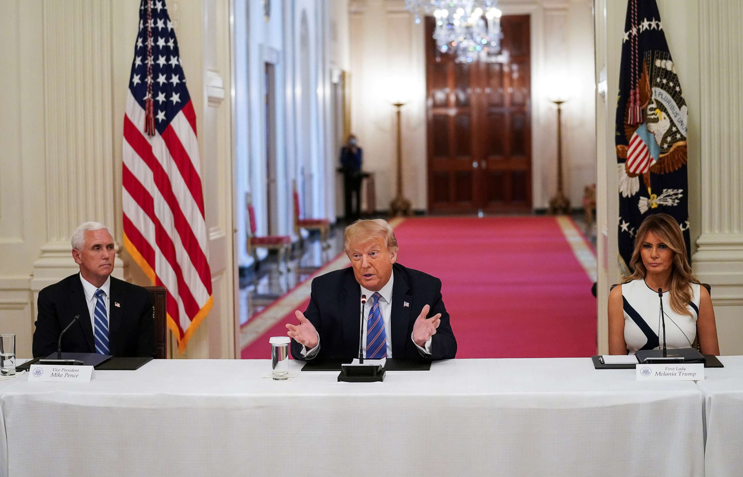 PHOTO: President Donald Trump is flanked by Vice President Mike Pence and first lady Melania Trump as he speaks during an event on reopening schools amid the coronavirus pandemic in the East Room at the White House in Washington, July 7, 2020.