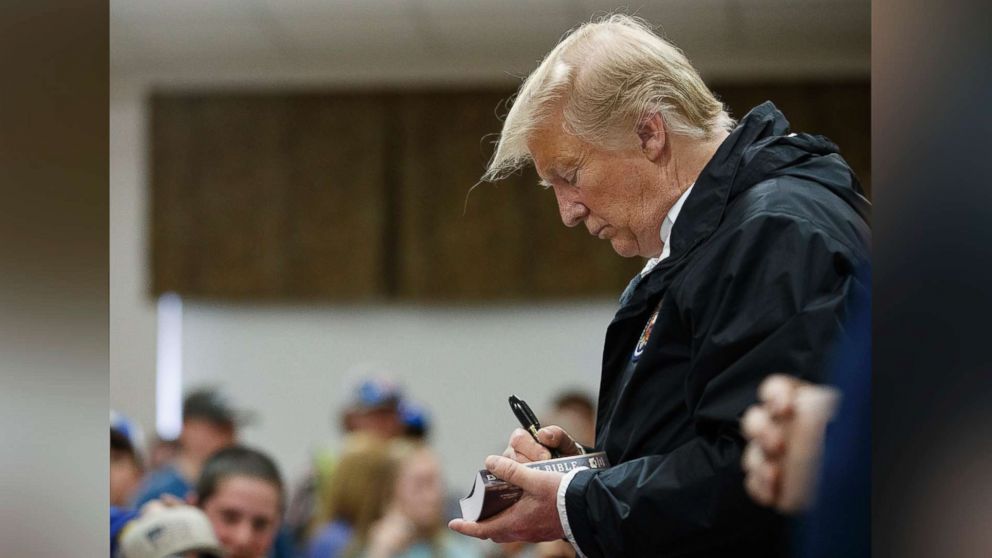 PHOTO: President Donald Trump signs a Bible as he greets people at Providence Baptist Church in Smiths Station, Ala., Friday, March 8, 2019, during a tour of areas where tornadoes killed 23 people in Lee County, Ala.