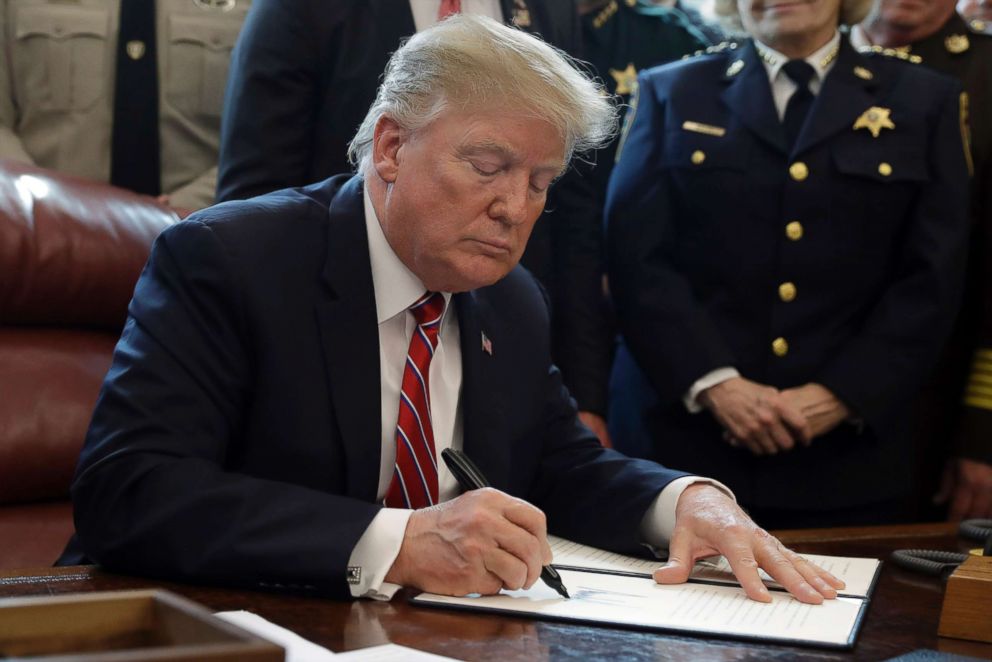 PHOTO: President Donald Trump signs the first veto of his presidency in the Oval Office,  March 15, 2019. Trump issued the first veto, overruling Congress to protect his emergency declaration for border wall funding.