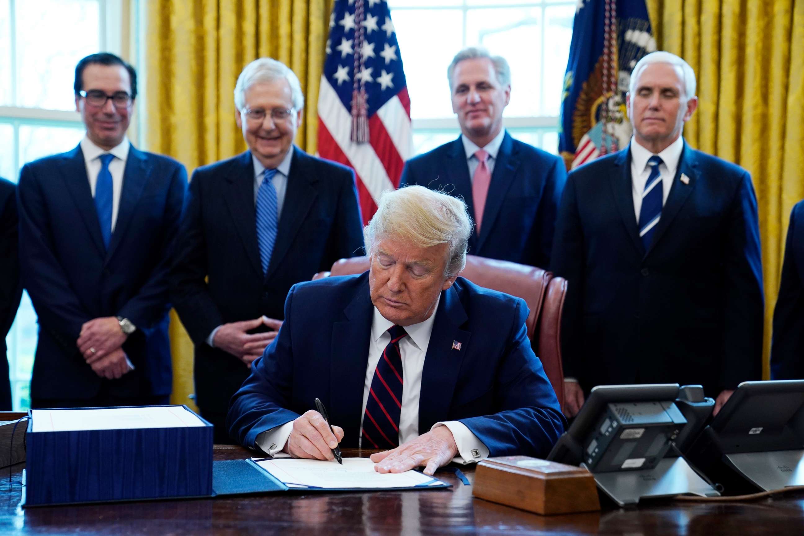 PHOTO: In this March 27, 2020 file photo, President Donald Trump signs the coronavirus stimulus relief package, at the White House in Washington.