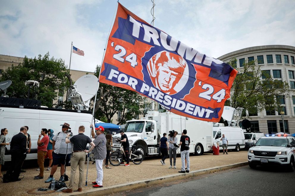 PHOTO: A supporter of Donald Trump carries a large flag outside the E. Barrett Prettyman U.S. District Court House ahead of Trump's arrival on Aug. 3, 2023, in Washington, D.C.