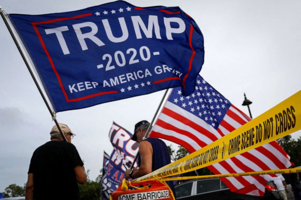 PHOTO: Supporters of former U.S. President Donald Trump wave flags as they gather outside his Mar-a-Lago home after Trump said that FBI agents raided it in Palm Beach, Florida, Aug. 9, 2022.