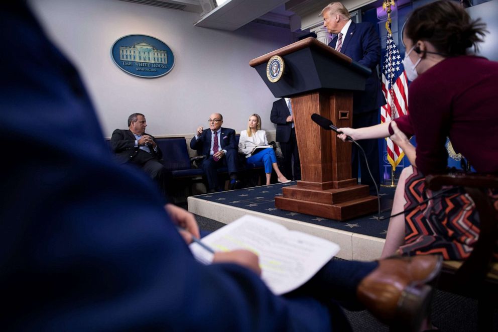 PHOTO: US President Donald Trump, and others listen while former New York City Mayor Rudy Giuliani speaks during a briefing at the White House September 27, 2020, in Washington, DC.