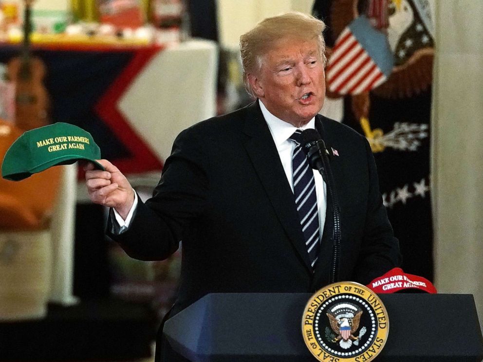 PHOTO: President Donald Trump holds up a Make Our Farmers Great Again hat as he speaks during the 2018 Made in America Product Showcase event July 23, 2018 at the White House in Washington.
