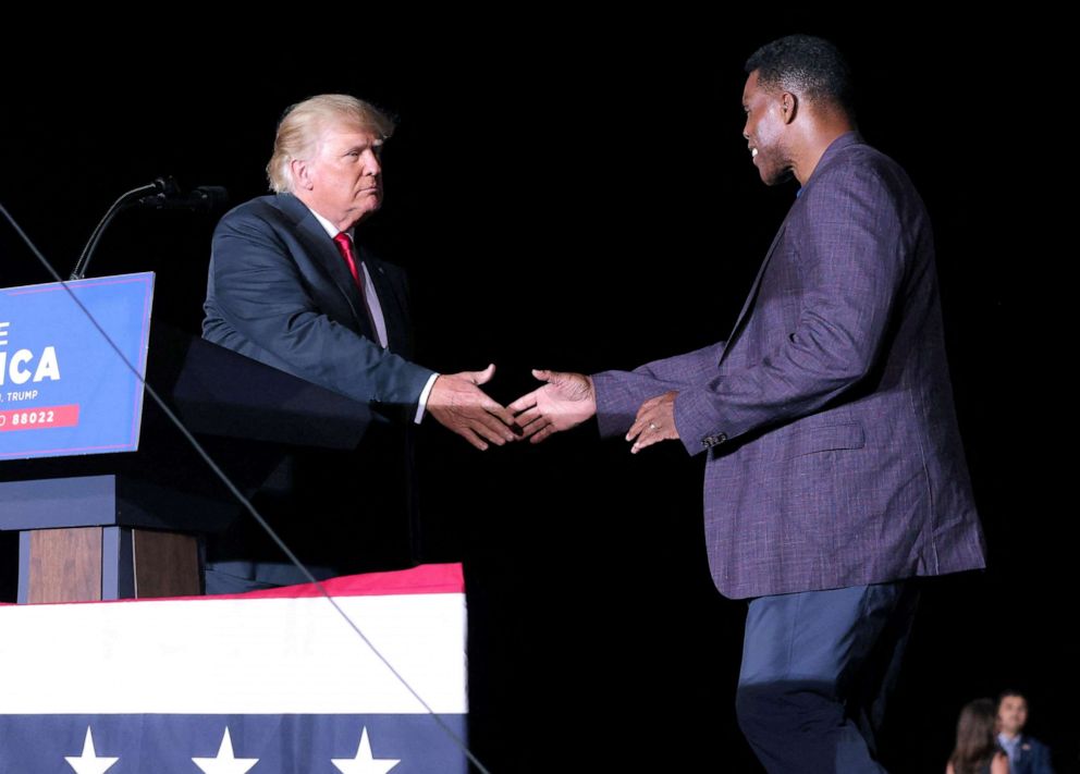 PHOTO: Former college football star and current senatorial candidate Herschel Walker shakes hands with former President Donald Trump during a rally in Perry, Georgia, September 25, 2021.