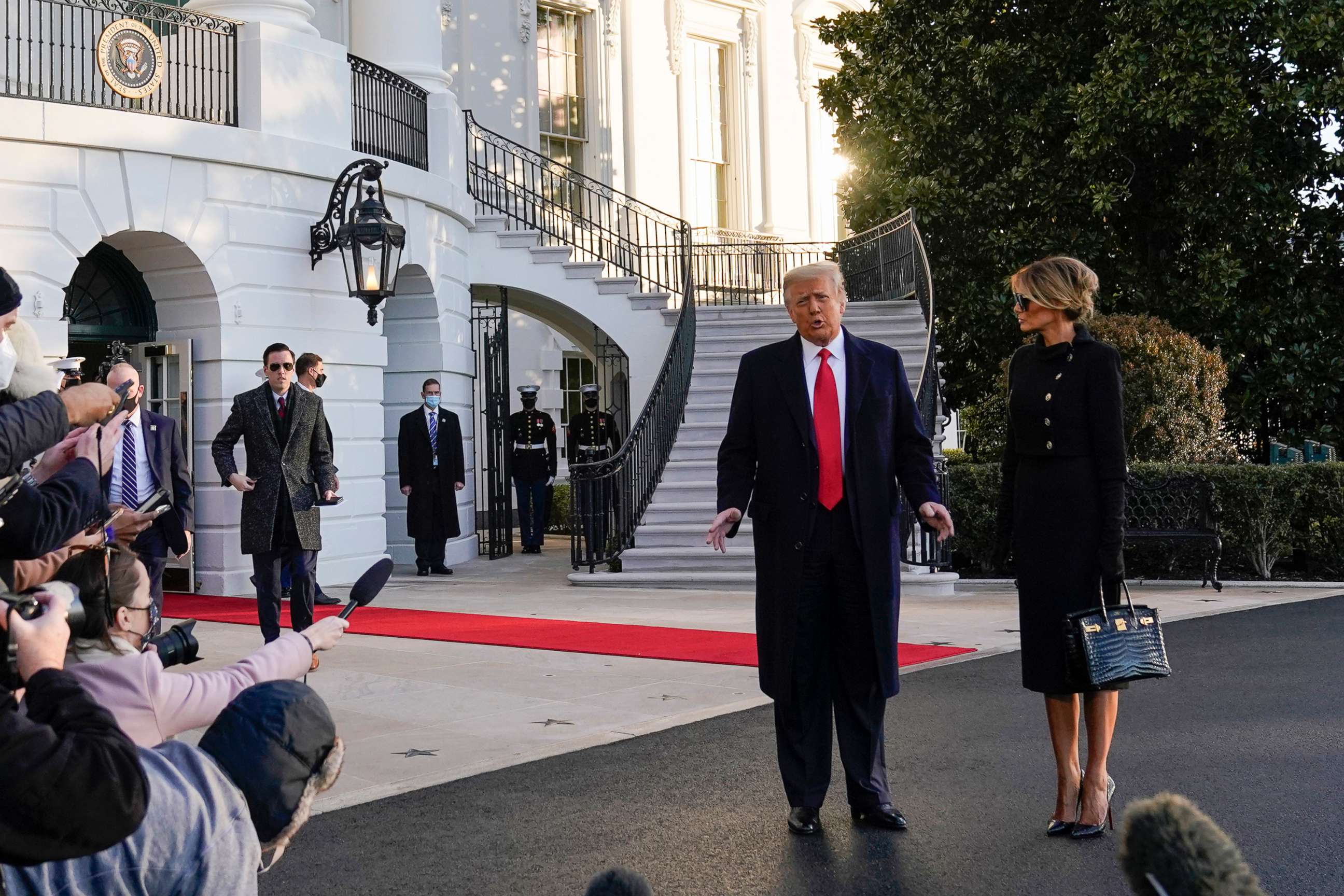 PHOTO: President Donald Trump and first lady Melania Trump stop to talk with the media as they walk to board Marine One on the South Lawn of the White House, Jan. 20, 2021, in Washington, D.C.