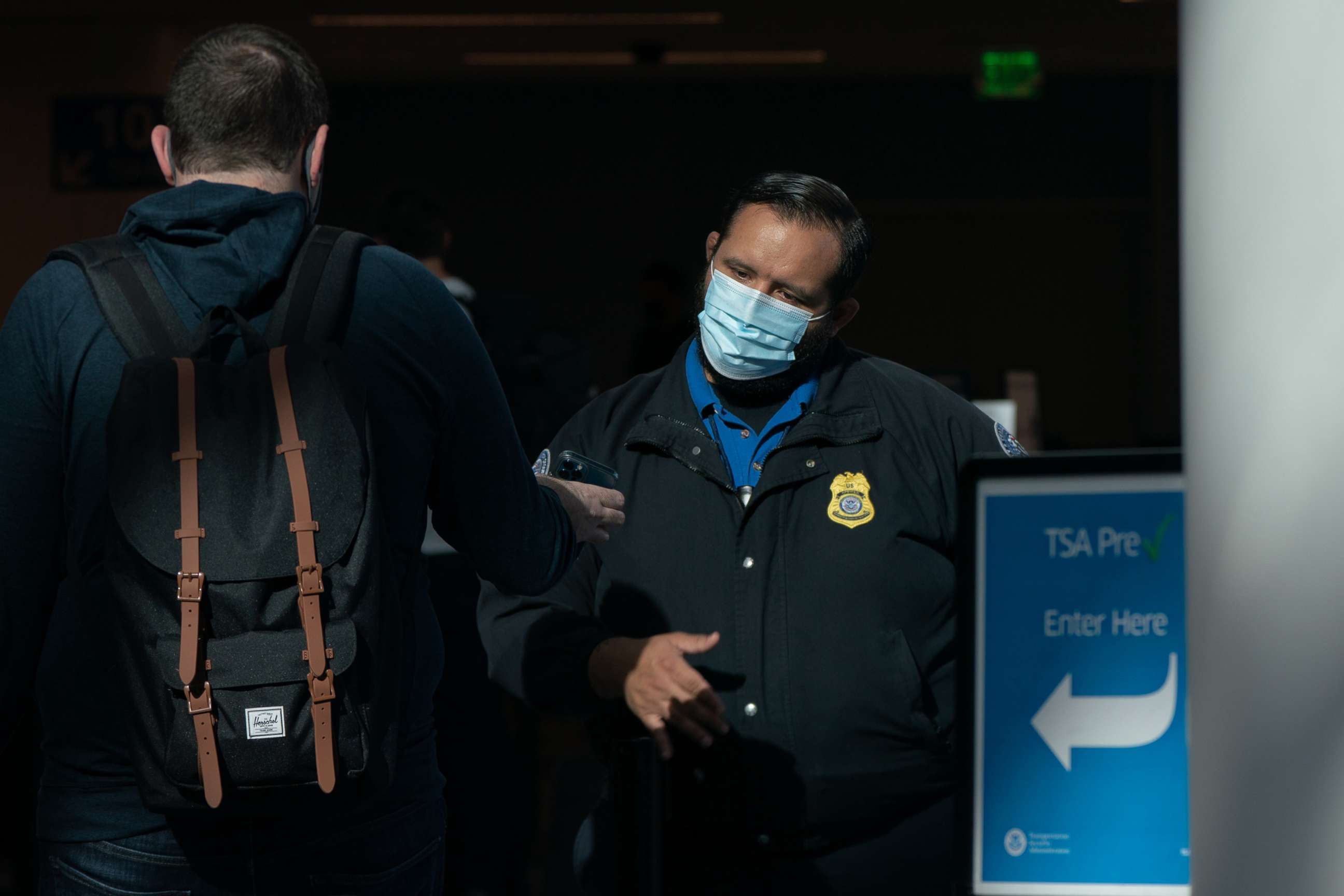PHOTO: A Transportation Security Administration (TSA) agent wearing a protective mask checks a traveler's identification at Los Angeles International Airport, May 28, 2021.