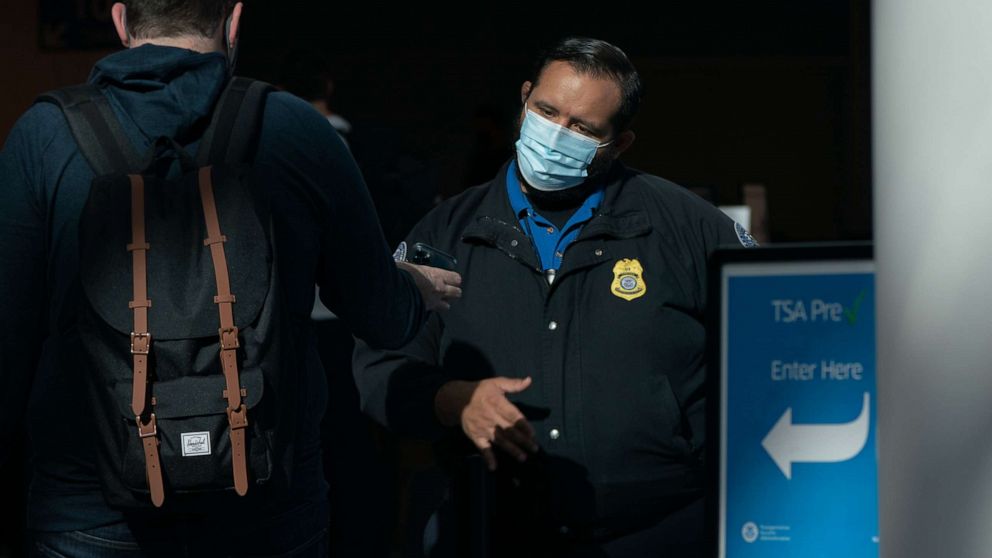 PHOTO: A Transportation Security Administration (TSA) agent wearing a protective mask checks a traveler's identification at Los Angeles International Airport, May 28, 2021.