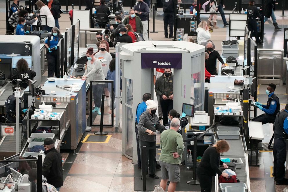 PHOTO: Travelers queue up to pass through the a security checkpoint in the terminal of Denver International Airport, Dec. 26, 2021, in Denver.