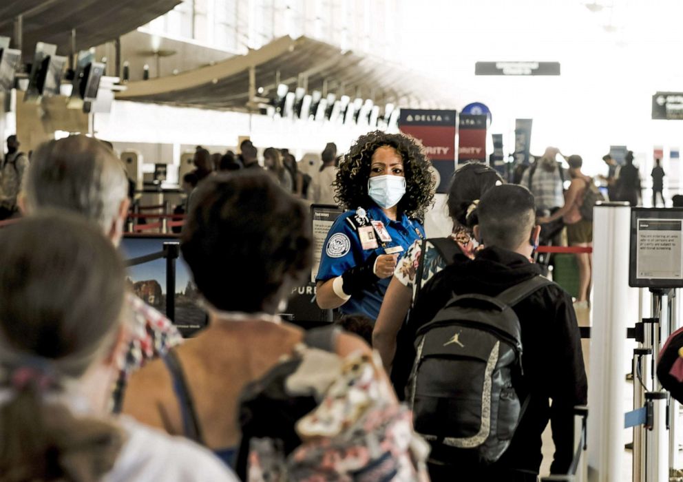 PHOTO: A Transportation Security Administration (TSA) agent guides travelers at a checkpoint in the Detroit Metropolitan Wayne County Airport (DTX) in Romulus, Mich., June 12, 2021.