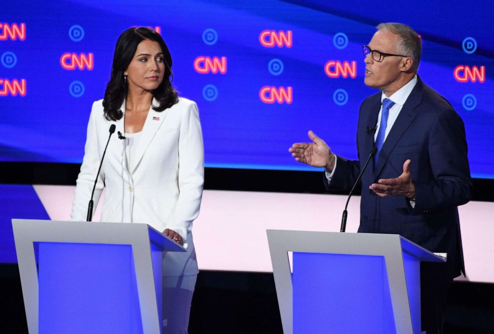 PHOTO: Democratic presidential hopefuls US Representative for Hawaii's 2nd congressional district Tulsi Gabbard (L) and Governor of Washington Jay Inslee (R) speak during the second round of the second Democratic primary debate.