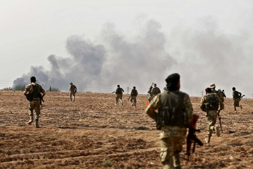 PHOTO: Pro-Turkish Syrian fighters cross the border into Syria as they take part in an offensive against Kurdish-controlled areas in northeastern Syria launched by the Turkish military, Oct. 11, 2019.