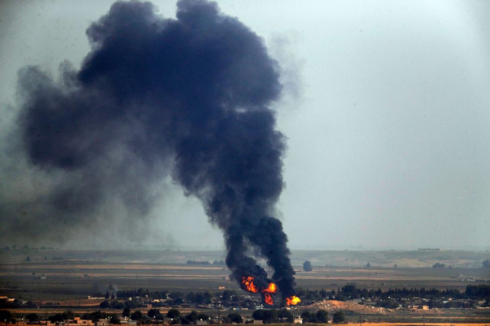 PHOTO: In this photo taken from the Turkish side of the border between Turkey and Syria, flames and smoke billow from a fire on a target in Ras al-Ayn, Syria, caused by shelling by Turkish forces, on Oct. 17, 2019.