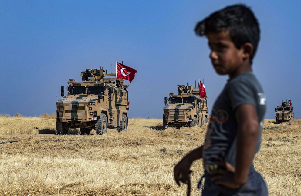 PHOTO: A Syrian boy watches as Turkish military vehicles, part of a U.S. military convoy, take part in joint patrol in the Syrian village of al-Hashisha along the border with Turkey, Oct. 4, 2019.