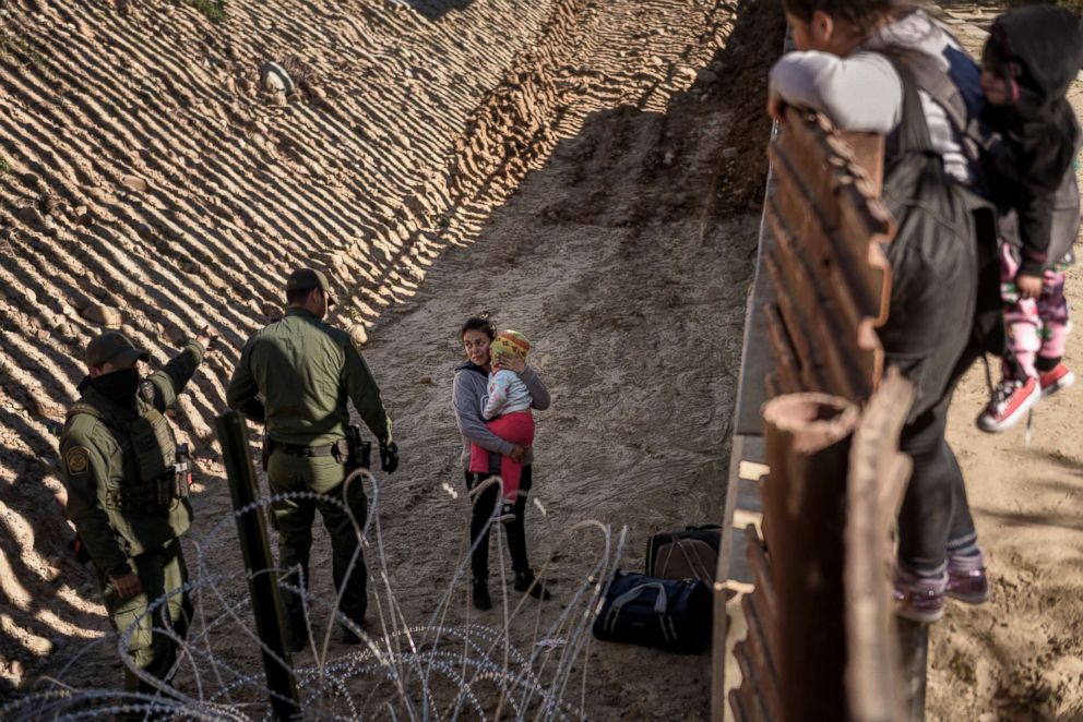 PHOTO: A Mexican migrant holds her baby as she is taken into custody by Border Patrol officers after she jumped the border fence to get into the U.S. side in San Diego, Calif., from Tijuana, Mexico, Dec. 29, 2018.