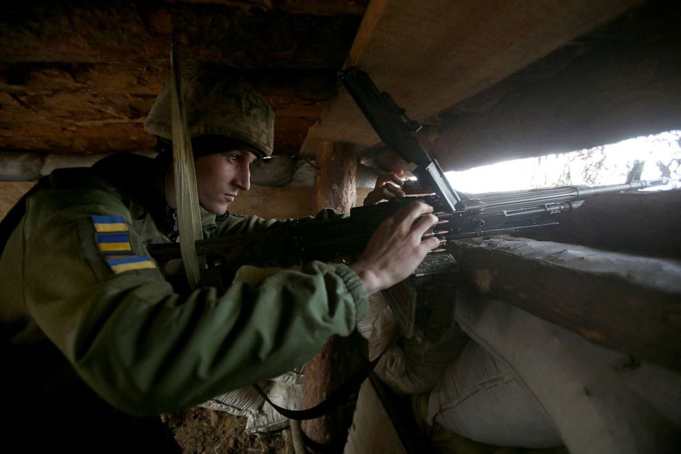 PHOTO: A Ukrainian serviceman loads a mashine gun in a dugout on the front line with Russia-backed separatists, not far from the settlement of Verkhnyotoretske, Donetsk region, April 28, 2021. 