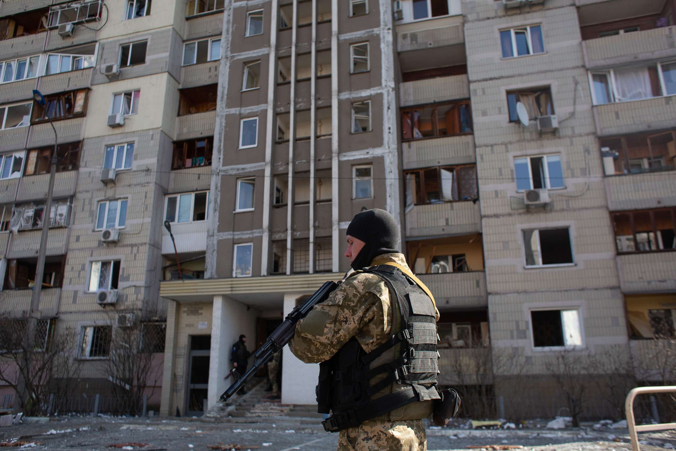 PHOTO: A Ukrainian serviceman stands by a residential building which got hit by rocket debris, March 17, 2022, in Kyiv, Ukraine. 