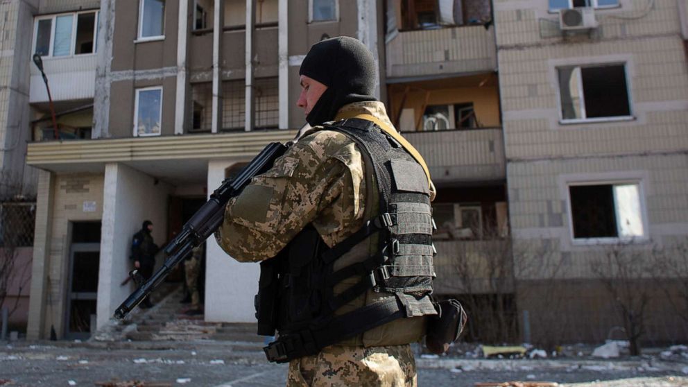 PHOTO: A Ukrainian serviceman stands by a residential building which got hit by rocket debris, March 17, 2022, in Kyiv, Ukraine. 