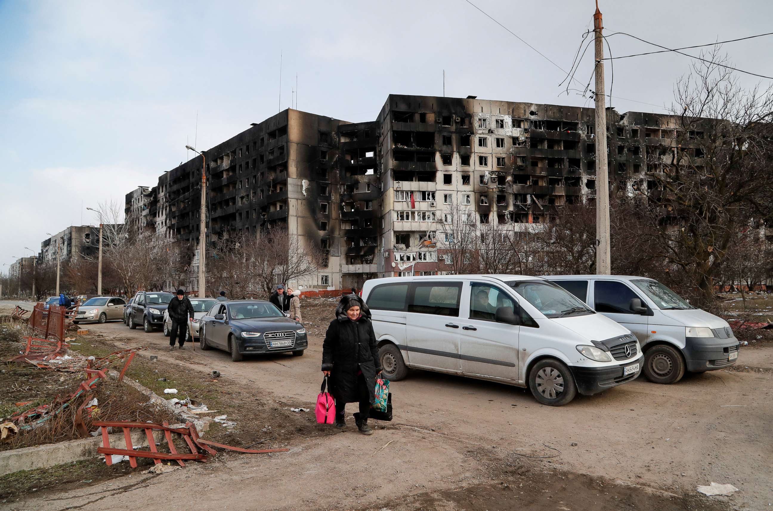 PHOTO: People walk near blocks of apartments, which were destroyed during Ukraine-Russia conflict in the besieged southern port city of Mariupol, Ukraine. March 17, 2022.