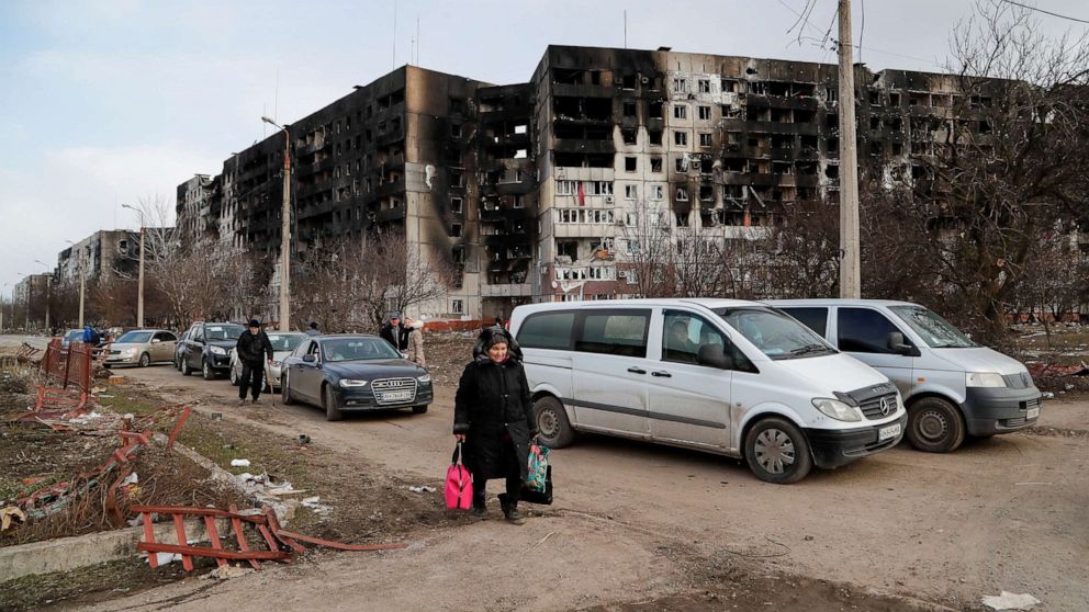 PHOTO: People walk near blocks of apartments, which were destroyed during Ukraine-Russia conflict in the besieged southern port city of Mariupol, Ukraine. March 17, 2022.
