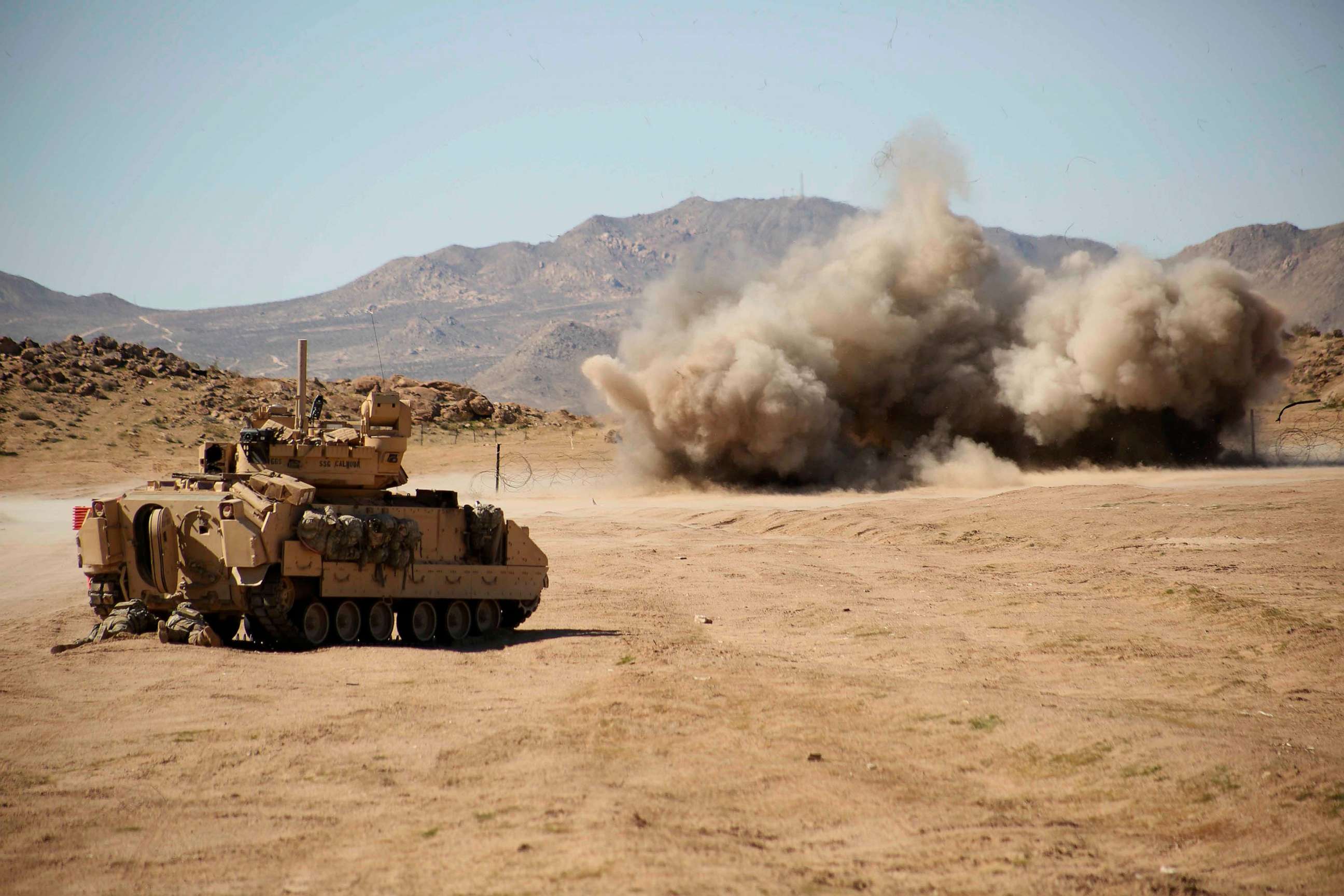 PHOTO: U.S. Soldiers, assigned to the 2nd Brigade, 1st Cavalry Division, 1st Squadron, 9th Cavalry Regiment, take cover as a Bangalore Torpedo Demolition Charge explodes in Fort Irwin, Calif., Feb 19, 2017.