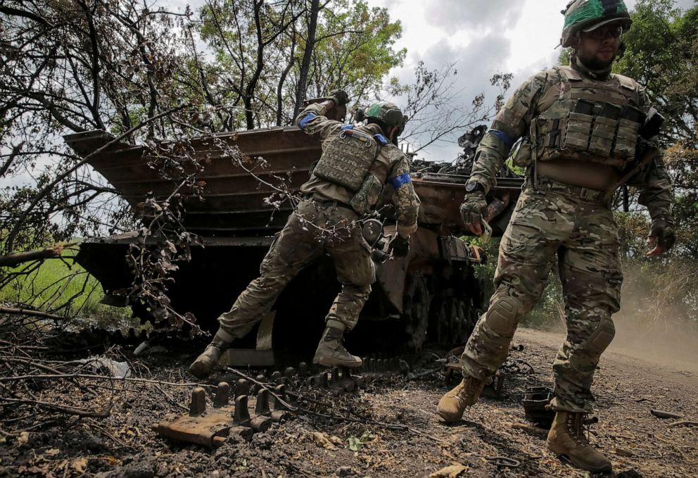 PHOTO: Ukrainian service members check a destroyed Russian a BMP-2 infantry fighting vehicle, amid Russia's attack on Ukraine, near the front line in the newly liberated village Storozheve in Donetsk region, Ukraine, June 14, 2023.