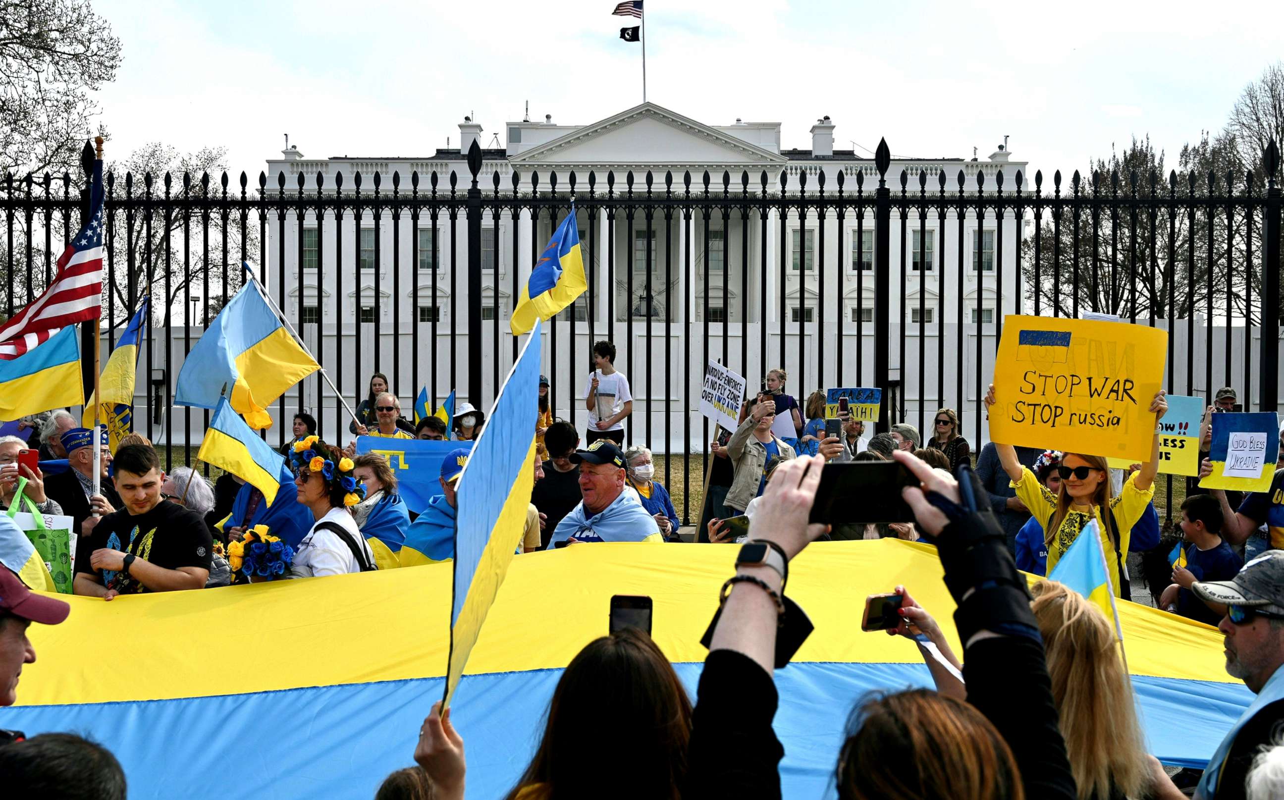 PHOTO: Supporters hold up signs and Ukrainian flags during a rally protesting the Russian invasion of Ukraine at Lafayette Square across the White House in Washington, D.C., March 6, 2022. 