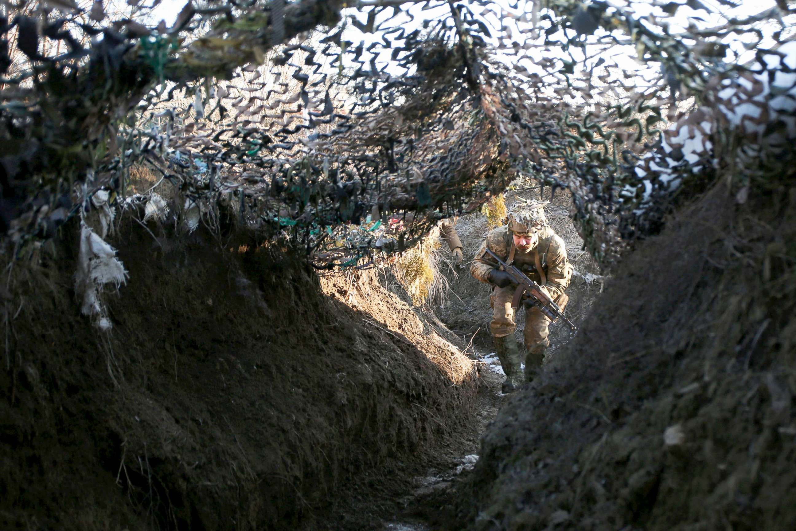 PHOTO: A member of Ukrainian Territorial Defense Forces military reserve walks on a trench on the frontline with Russia-backed separatists near to Avdiivka, Donetsk,  southeastern Ukraine, Jan. 8, 2022. 