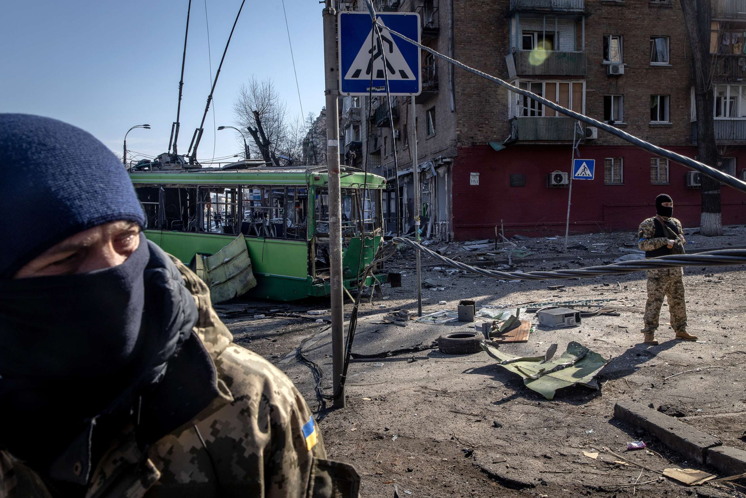 PHOTO: Members of the Ukrainian military stand amid debris from a damaged residential apartment block caused after a Russian rocket was shot down by Ukrainian air defenses on March 14, 2022, in Kyiv, Ukraine.