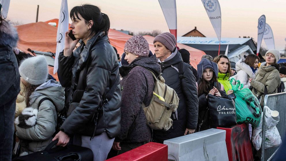 PHOTO: People line up to get into the buses for further transportation at the Polish-Ukrainian border crossing on March 18, 2022, in Medyka, Poland.