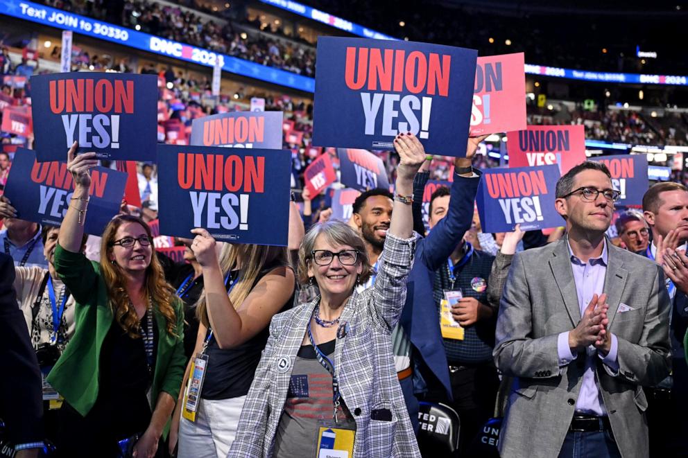 PHOTO: Delegates and attendees cheer as they hold "Union Yes!" signs on the first day of the Democratic National Convention in Chicago, Aug. 19, 2024.