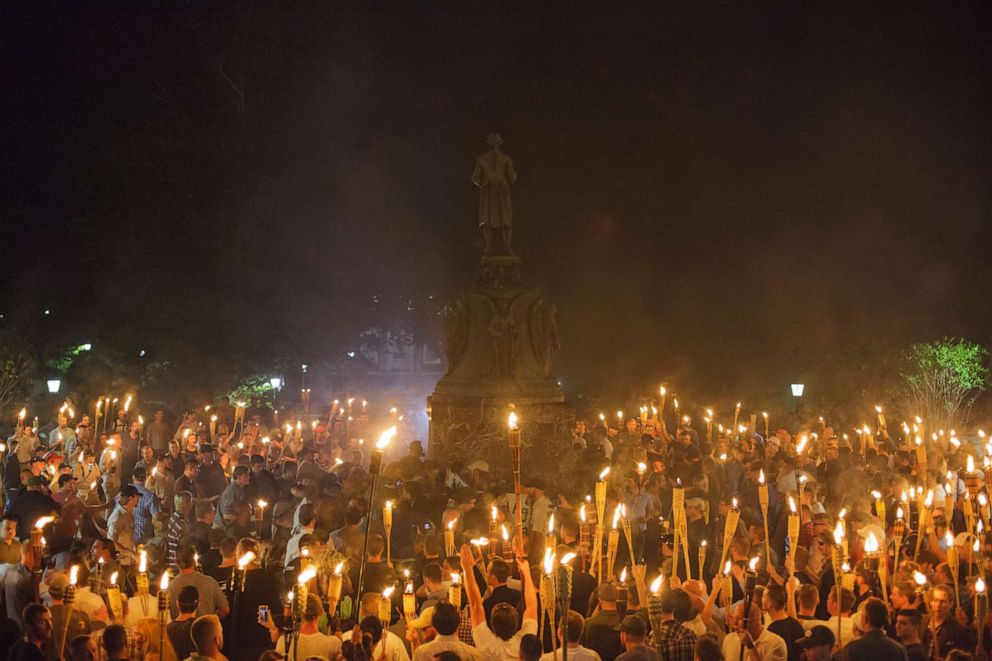 PHOTO: People participate in a "Unite the Right" rally at the base of a statue of Thomas Jefferson after marching through the University of Virginia campus with torches in Charlottesville, Va., Aug. 11, 2017.