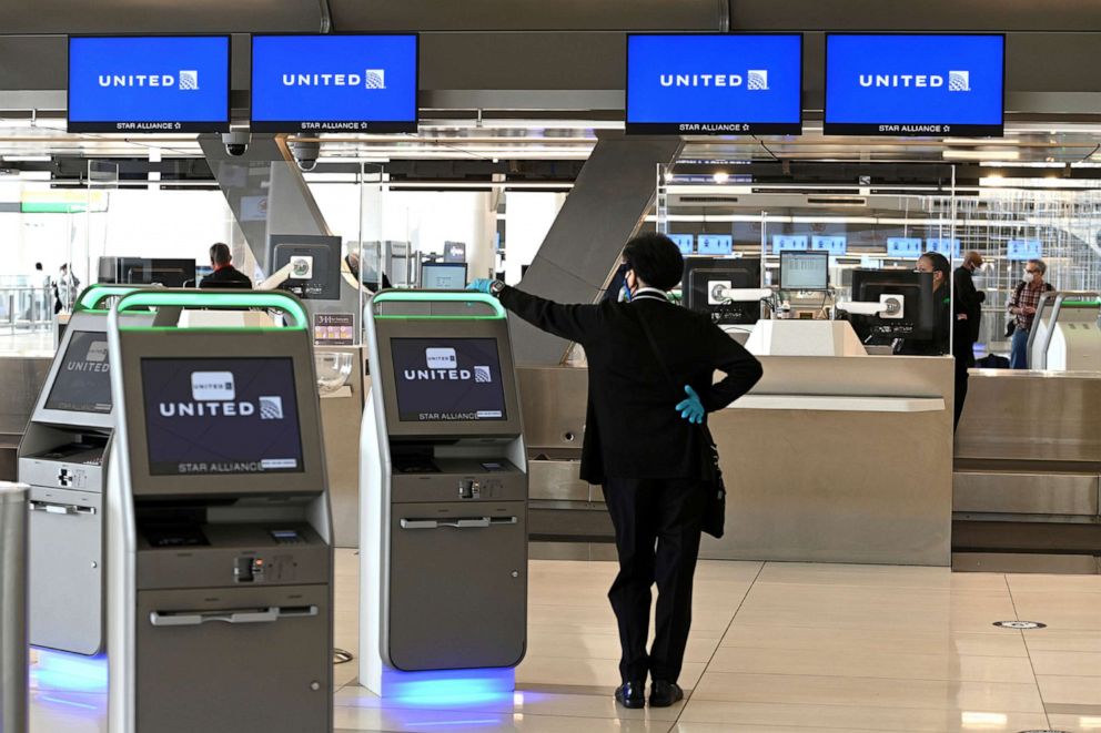 PHOTO: In this Oct. 1, 2020, file photo, a United Airline employee waits to assist travelers at the check-in counter at LaGuardia Airport in New York.