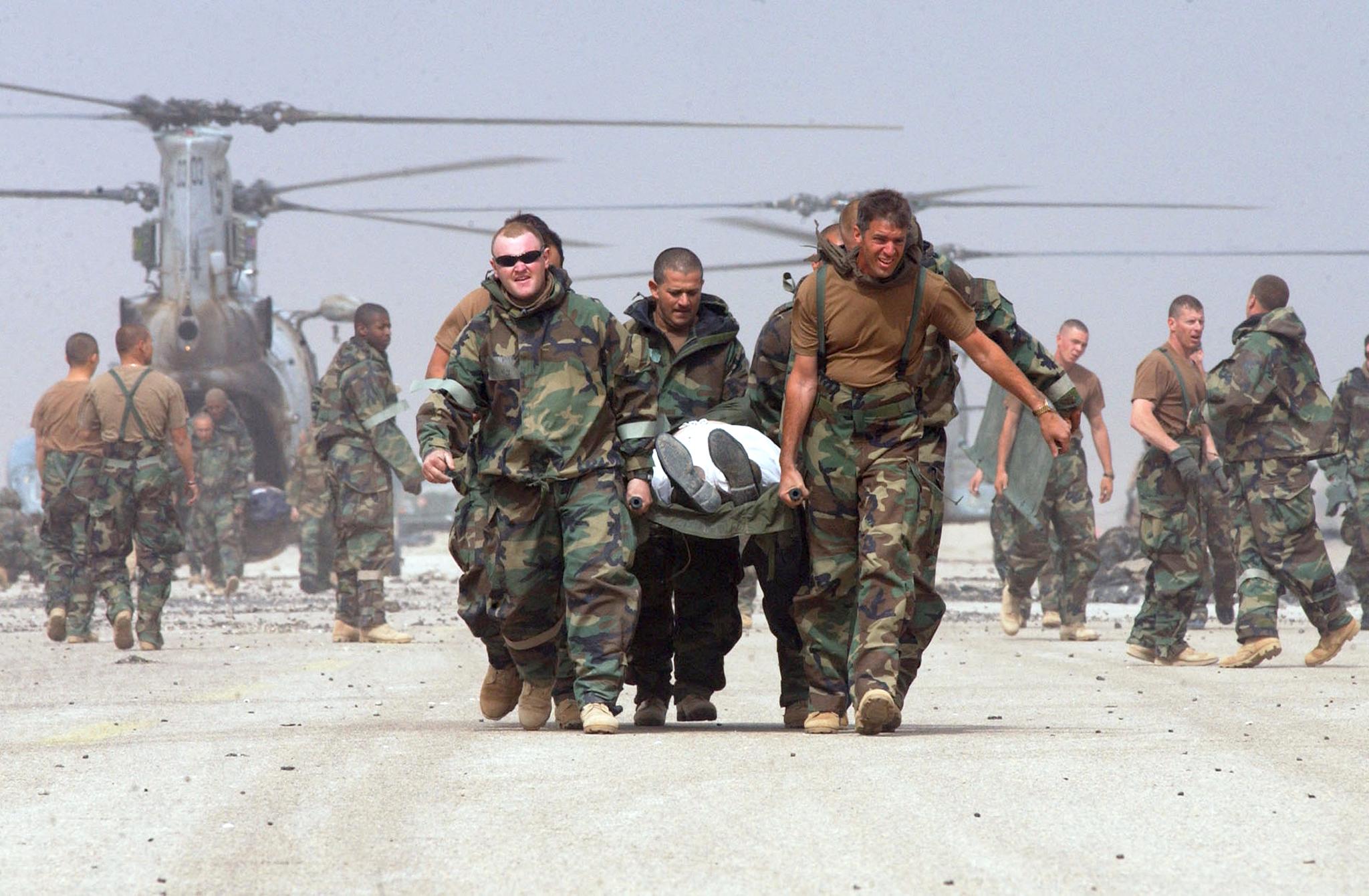 PHOTO: U.S. Army soldiers from the 3rd Infantry Division carry a wounded Iraqi prisoner of war to the battalion aid station on a captured airfield in southern Iraq, March 24, 2003.