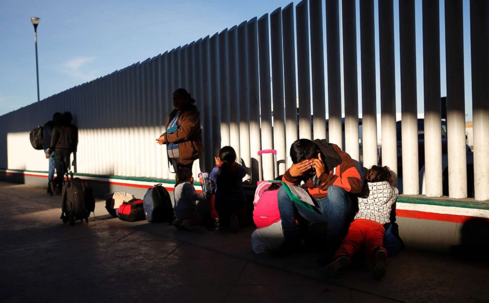 PHOTO: A migrant sits with his children as they wait to hear if their number is called to apply for asylum in the United States, Jan. 25, 2019, in Tijuana, Mexico.
