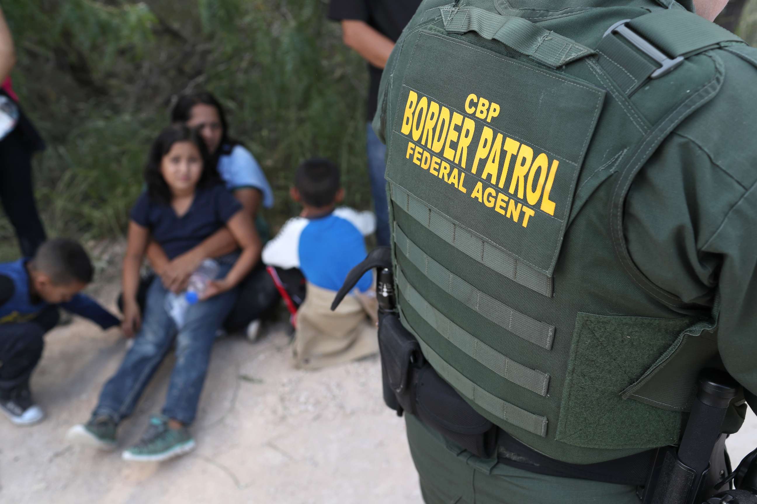 PHOTO: Central American asylum seekers wait as U.S. Border Patrol agents take them into custody on June 12, 2018 near McAllen, Texas.