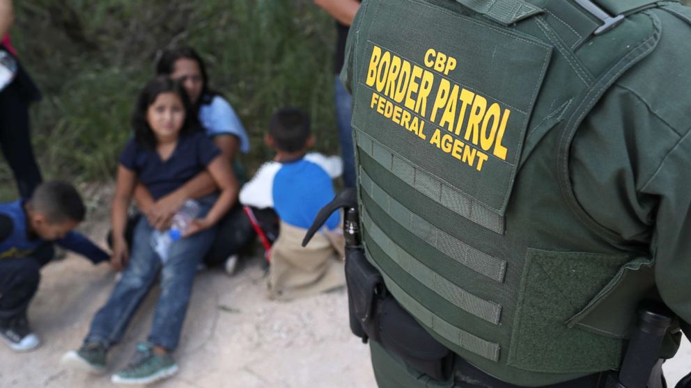 PHOTO: Central American asylum seekers wait as U.S. Border Patrol agents take them into custody on June 12, 2018 near McAllen, Texas.