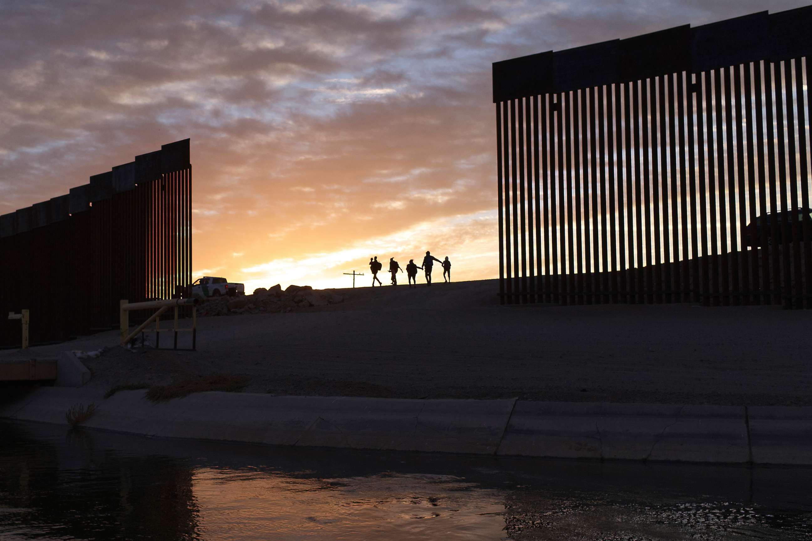 PHOTO: A pair of migrant families from Brazil pass through a gap in the border wall after crossing from Mexico into Yuma, Ariz., June 10, 2021, to seek asylum.