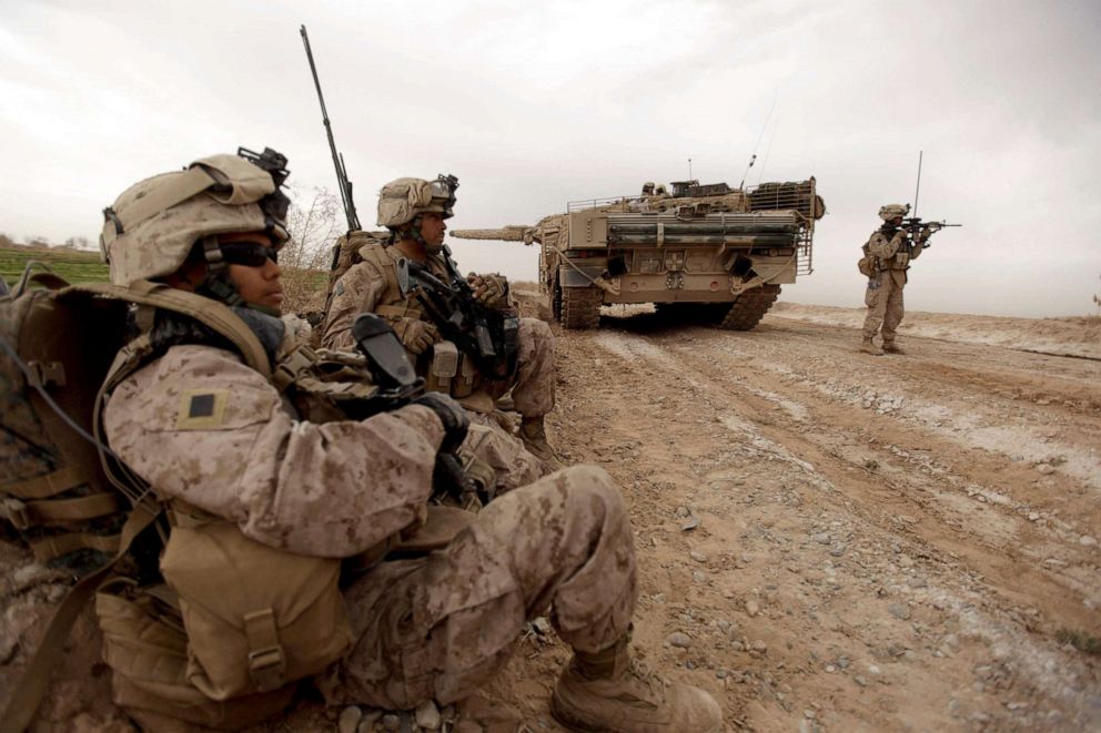 PHOTO: US marines with 1/3 marine Charlie Company patrol past a Danish army Leopard 2A5EK tank as they clear Improvised Explosive Device (IED)s from a main route in Trikh Nawar on the North Eastern outskirts of Marjah, Afghanistan, February 21, 2010.
